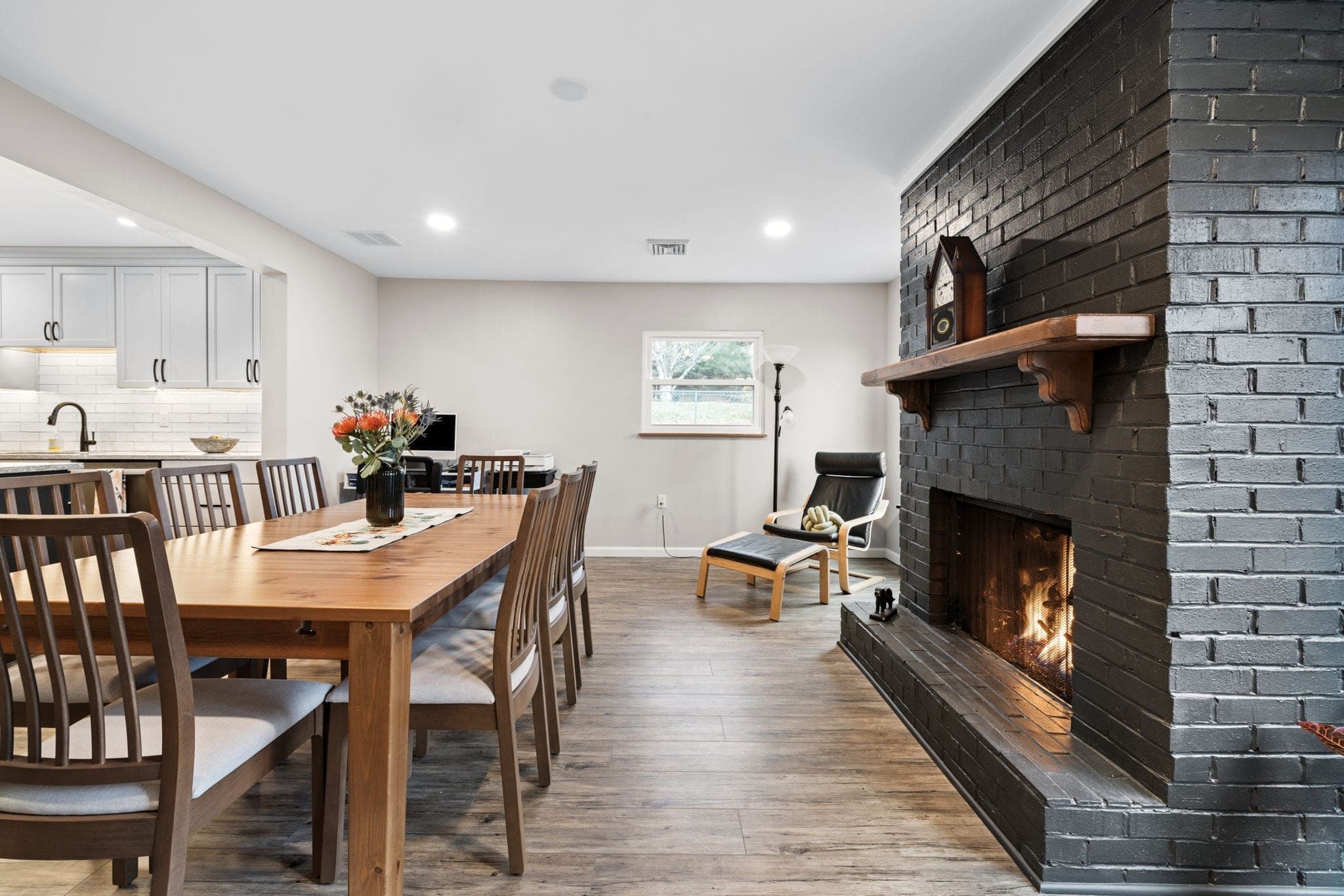 Dining room with painted black brick fireplace in a whole-home renovation on Hereford Drive in Oakdale, PA, built by Integrated Contracting & Renovations
