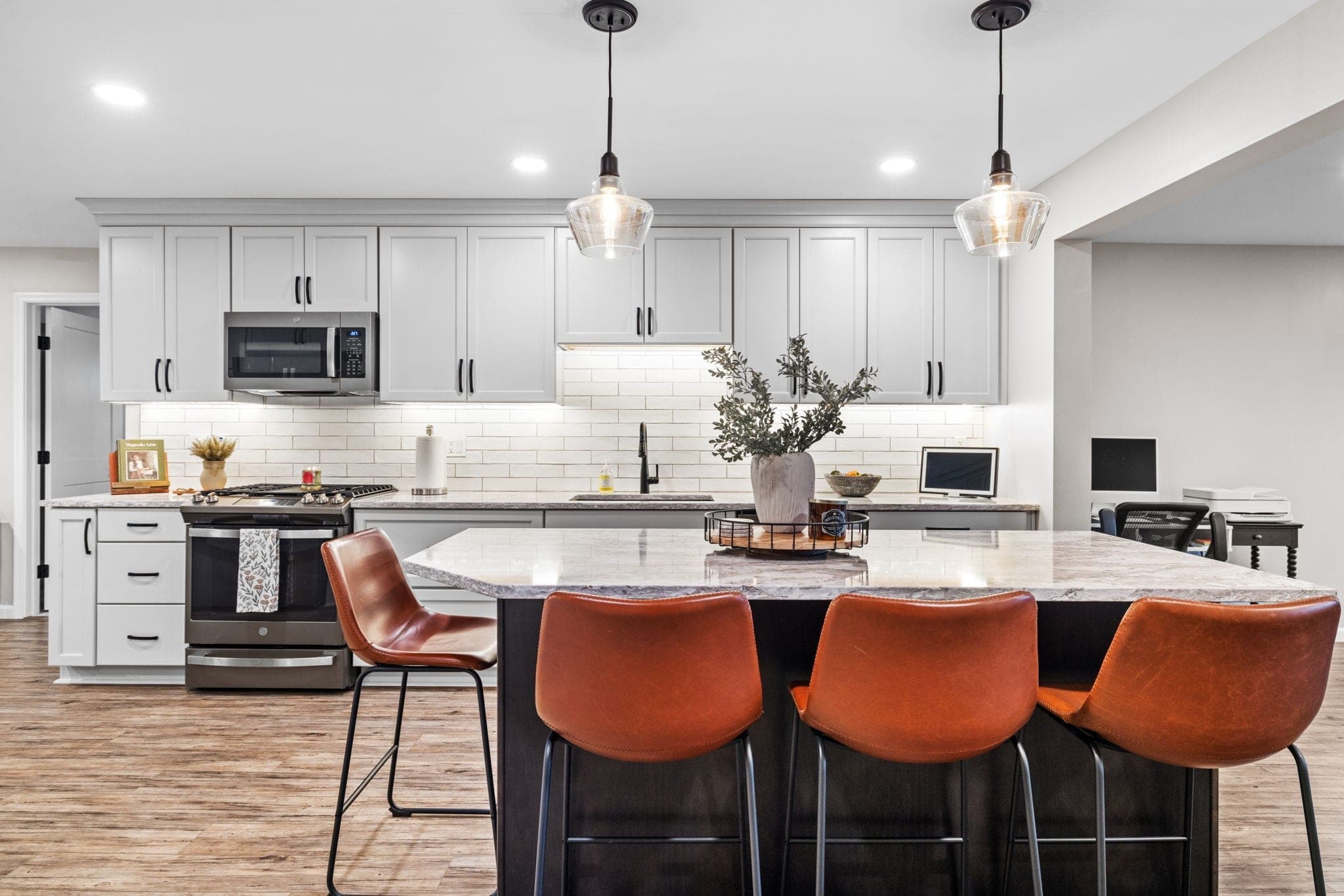 Renovated kitchen with gray cabinetry, island seating, and a home office nook on Hereford Drive in Oakdale, PA, built by Integrated Contracting & Renovations